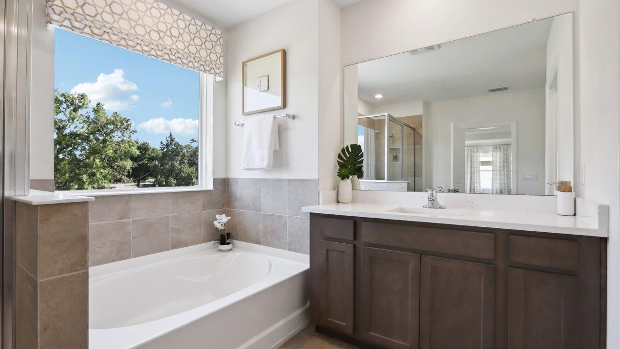 Modern bathroom with vanity sink, large wall mirror, and shower.