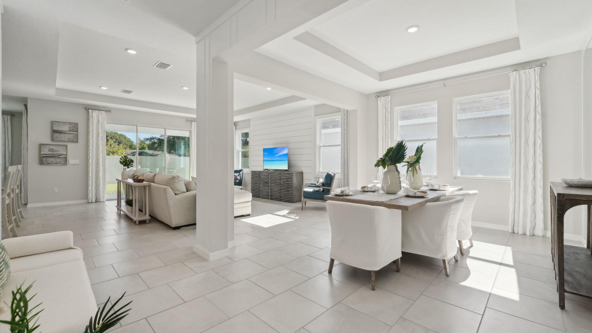 Open concept living area with couch seating and access to the backyard thru slider door.