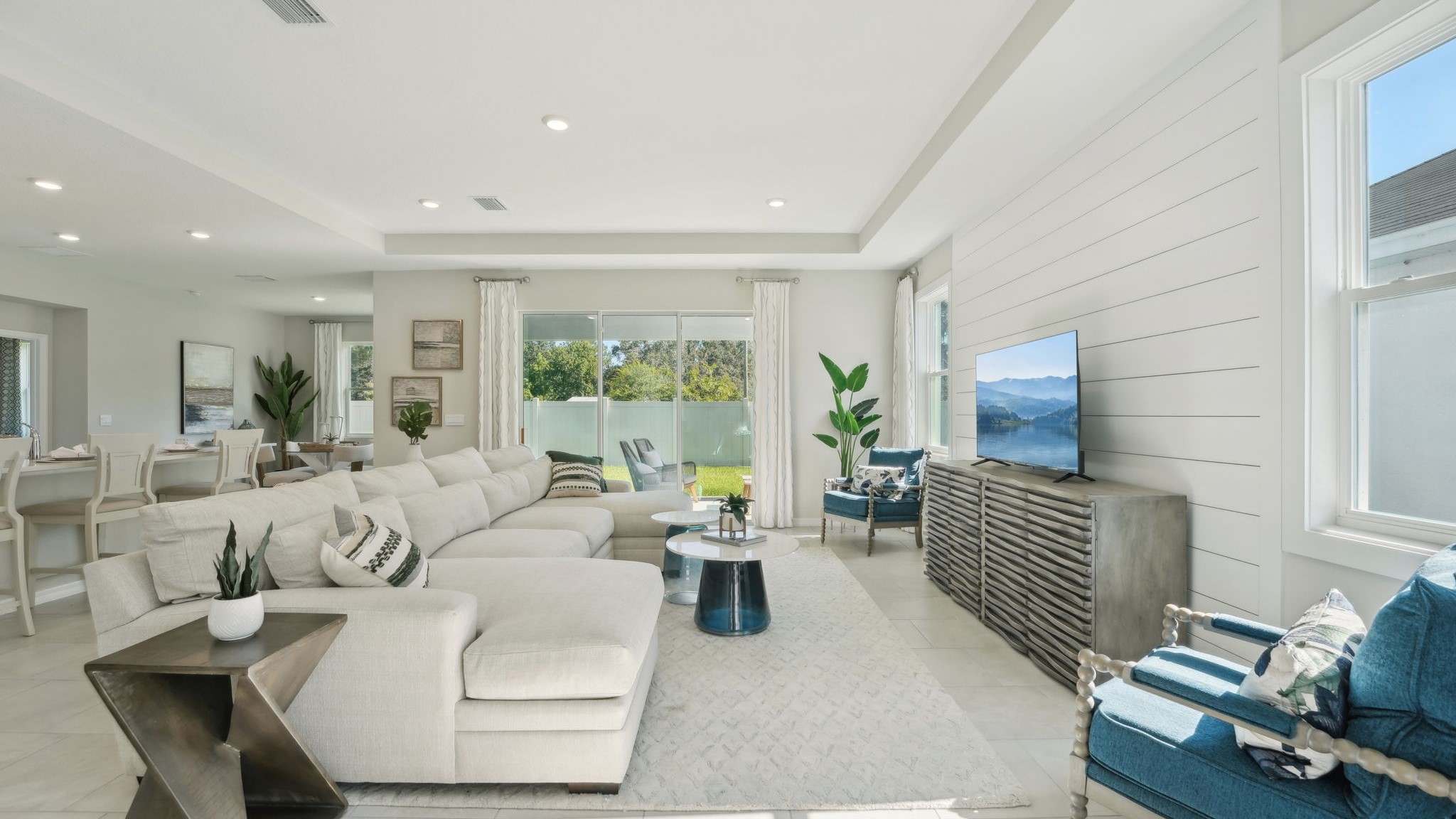 Open concept living area with couch seating and access to the backyard thru slider door.