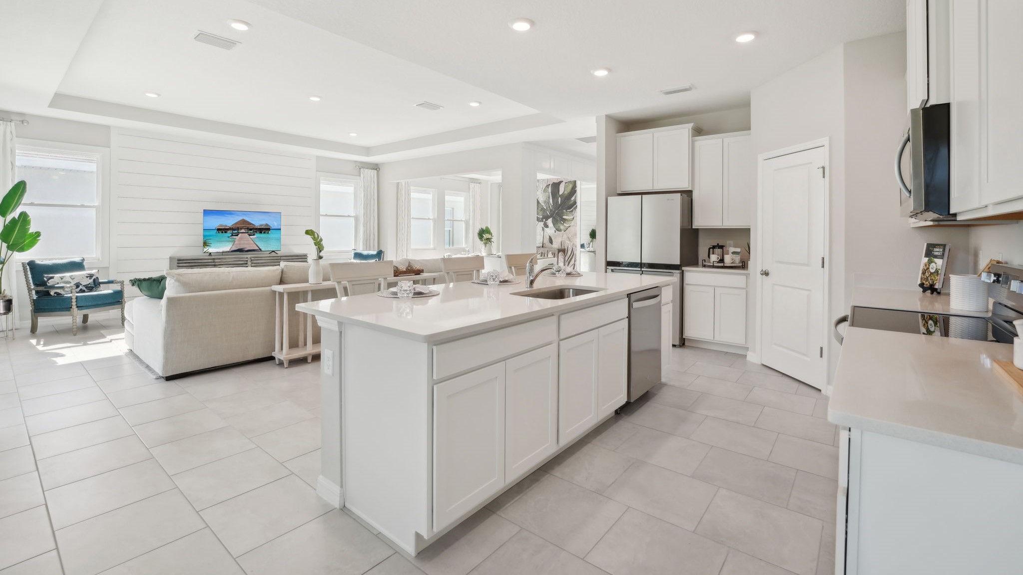 Kitchen with island seating, quartz counters, spacious pantry and stainless-steel appliances.