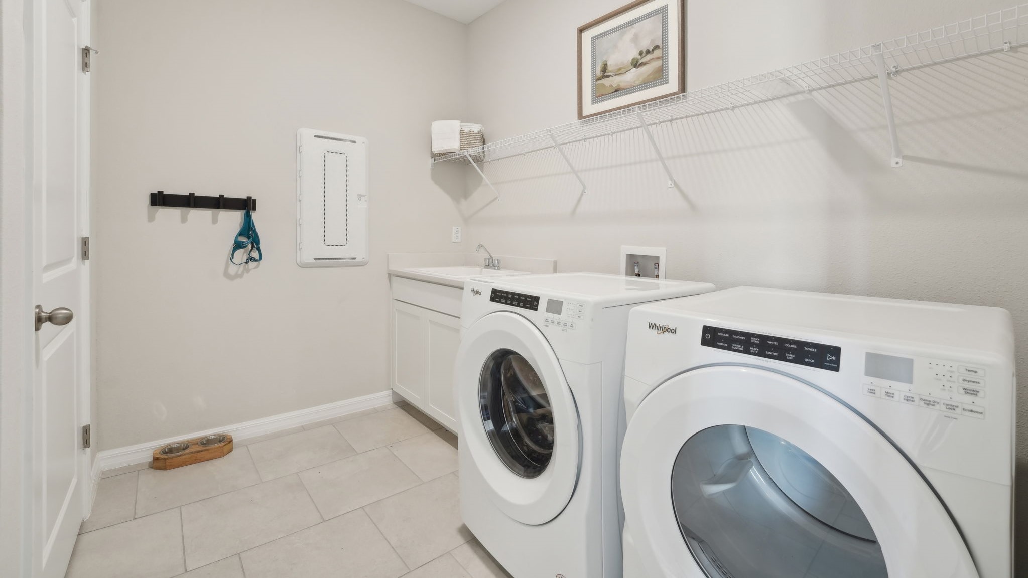 Laundry room with washer and dryer hookups and wall shelving.