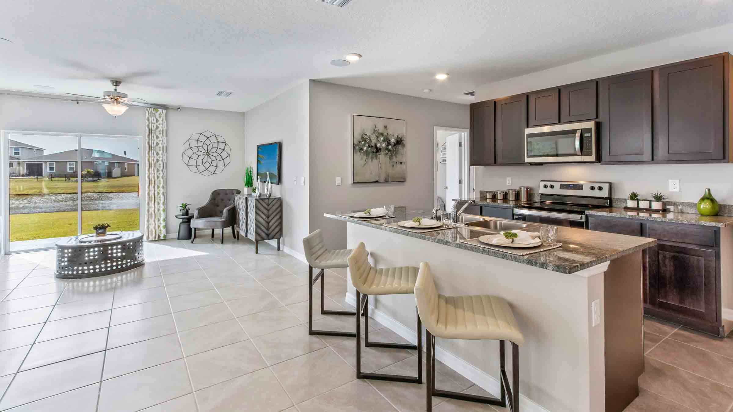 Kitchen with island seating, quartz counters, spacious pantry and stainless-steel appliances.