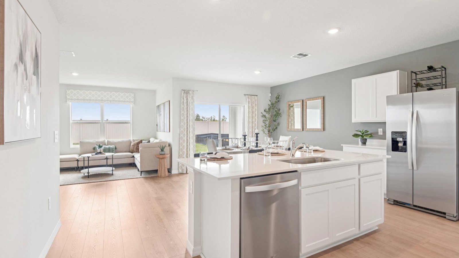 Kitchen with island seating, quartz counters, spacious pantry and stainless-steel appliances.