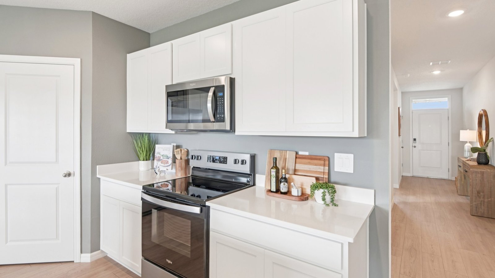 Kitchen with island seating, quartz counters, spacious pantry and stainless-steel appliances.