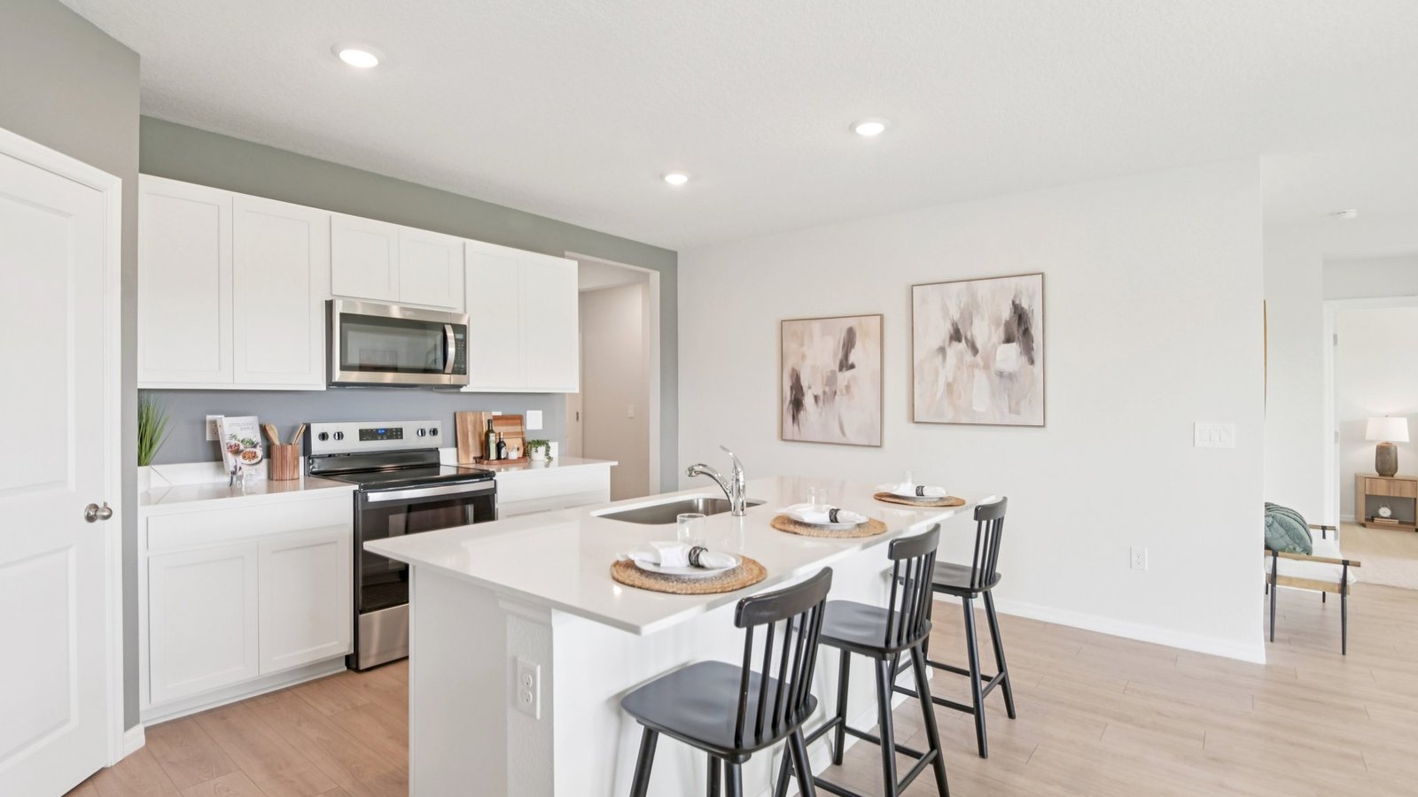 Kitchen with island seating, quartz counters, spacious pantry and stainless-steel appliances.