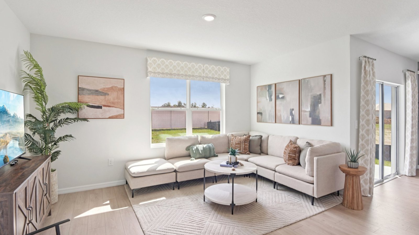 Open concept living area with couch seating and access to the backyard thru slider door.
