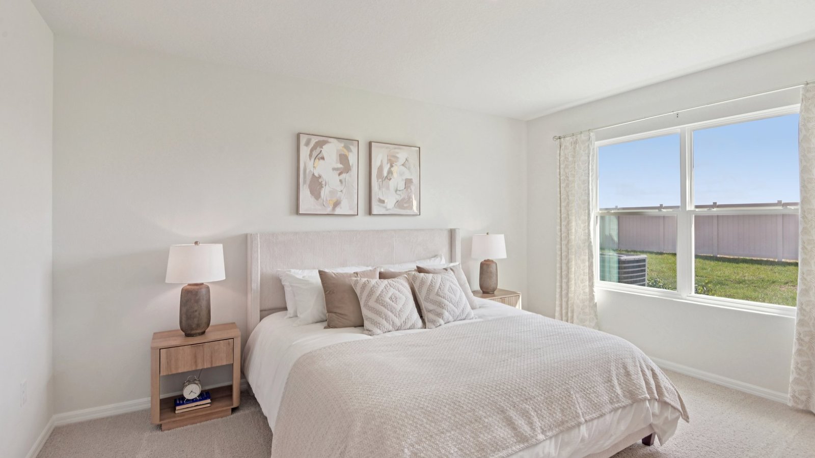 Spacious primary bedroom with king size bed, carpet flooring, natural lighting and a walk in closet.
