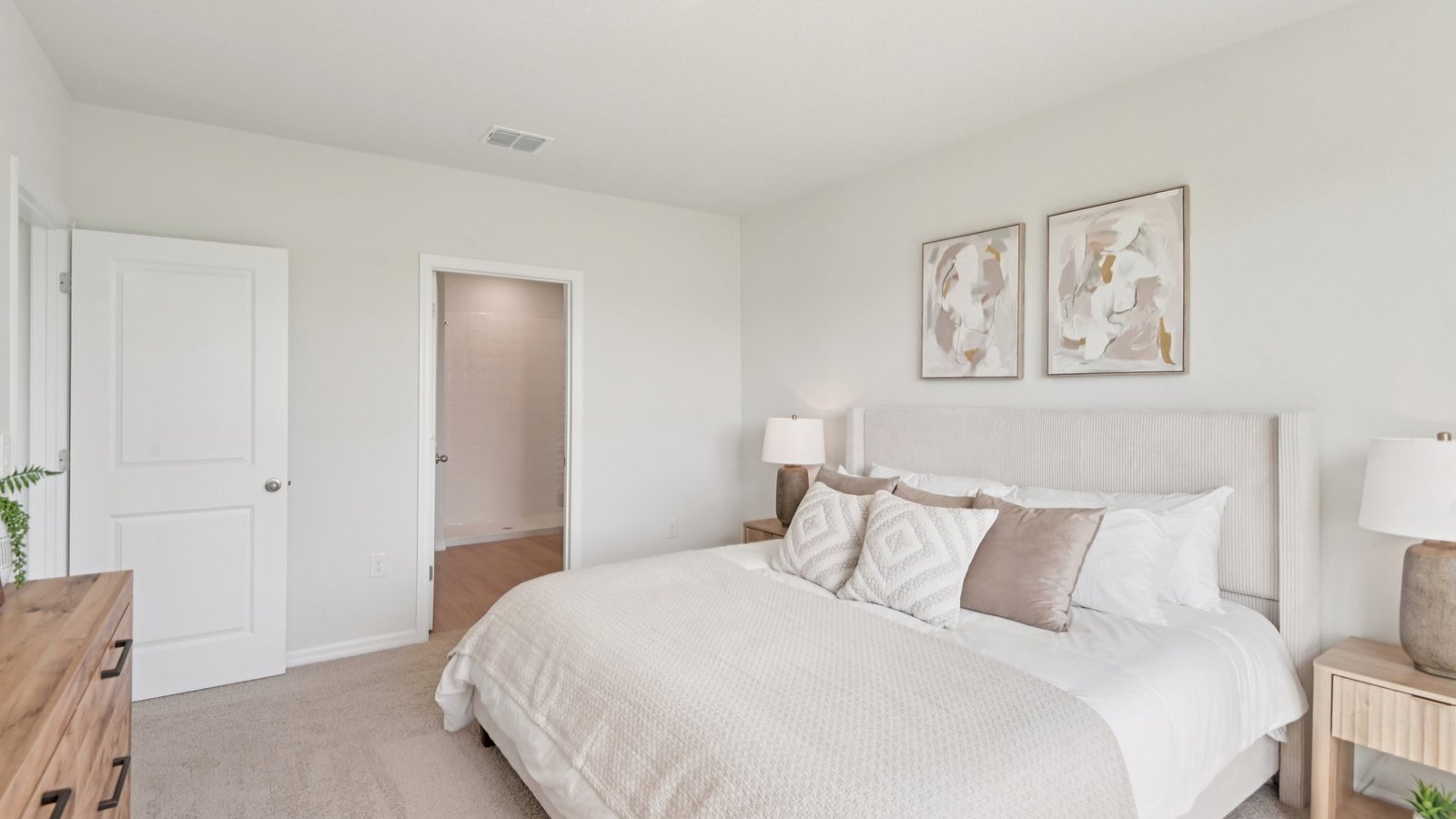 Spacious primary bedroom with king size bed, carpet flooring, natural lighting and a walk in closet.