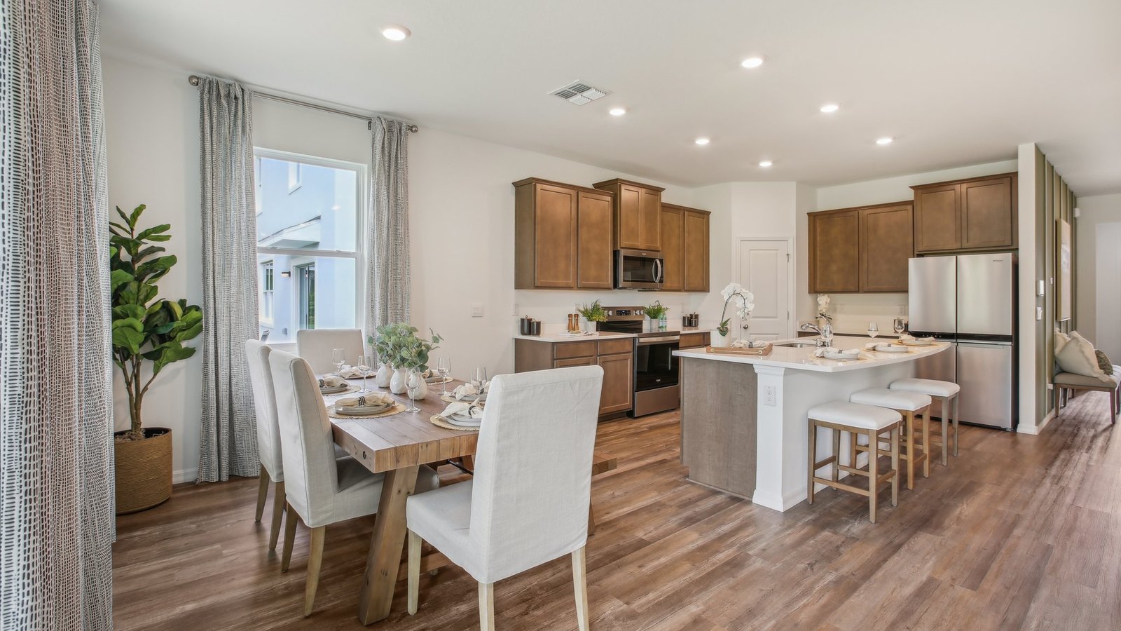 Dining room adjacent to the kitchen with table, chairs and tile flooring.