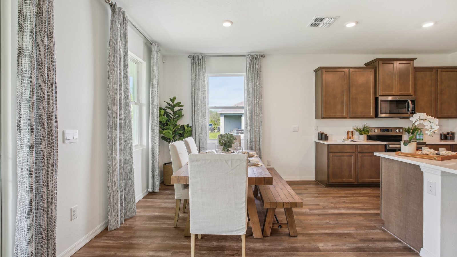 Dining room adjacent to the kitchen with table, chairs and tile flooring.