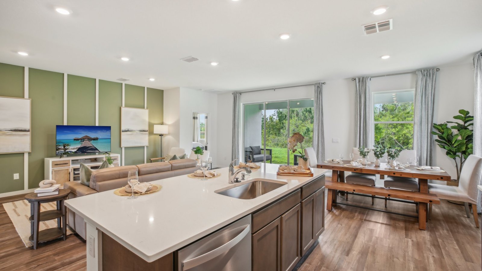 Kitchen with island seating, quartz counters, spacious pantry and stainless-steel appliances.