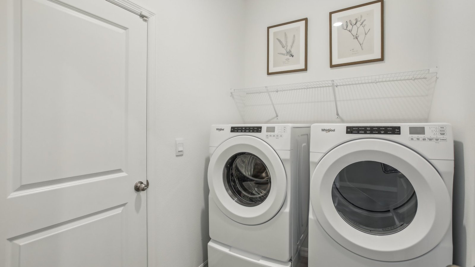 Laundry room with washer and dryer hookups and wall shelving.