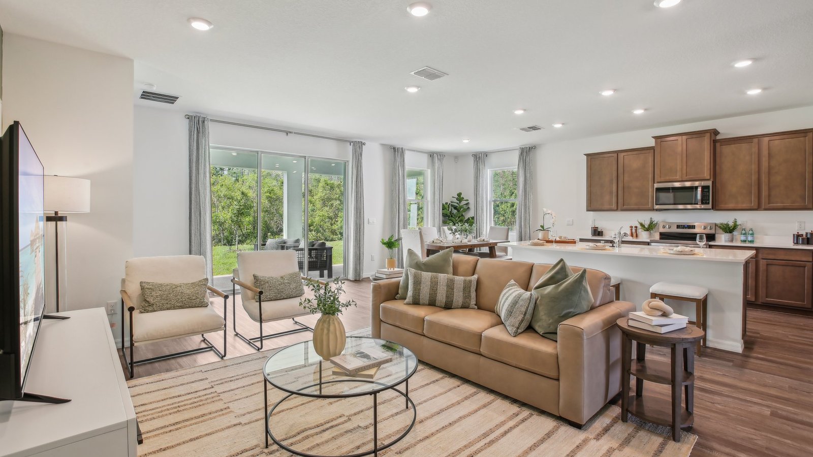 Open concept living area with couch seating and access to the backyard thru slider door.