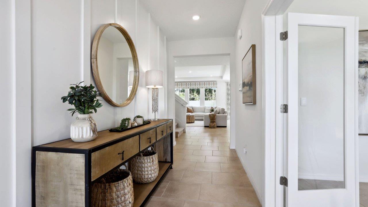 Home entry way thru the front door with tile flooring and a view to the living space