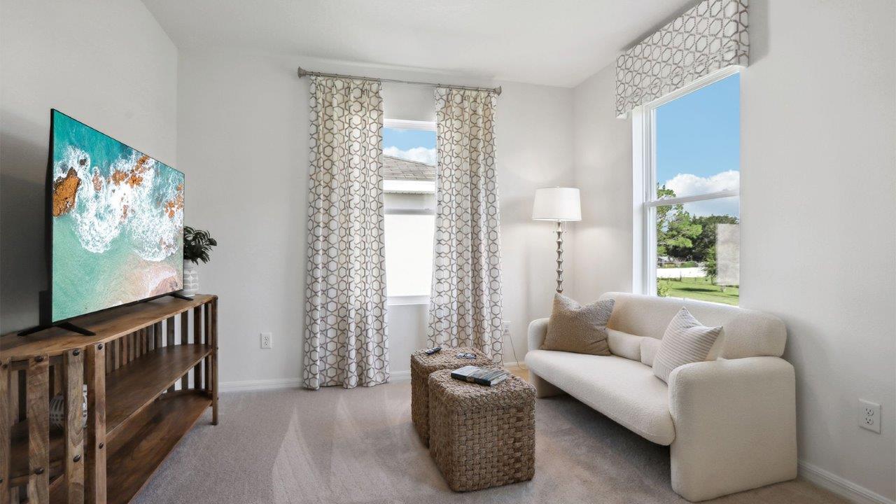 Spacious primary bedroom with king size bed, carpet flooring, natural lighting and a walk-in close