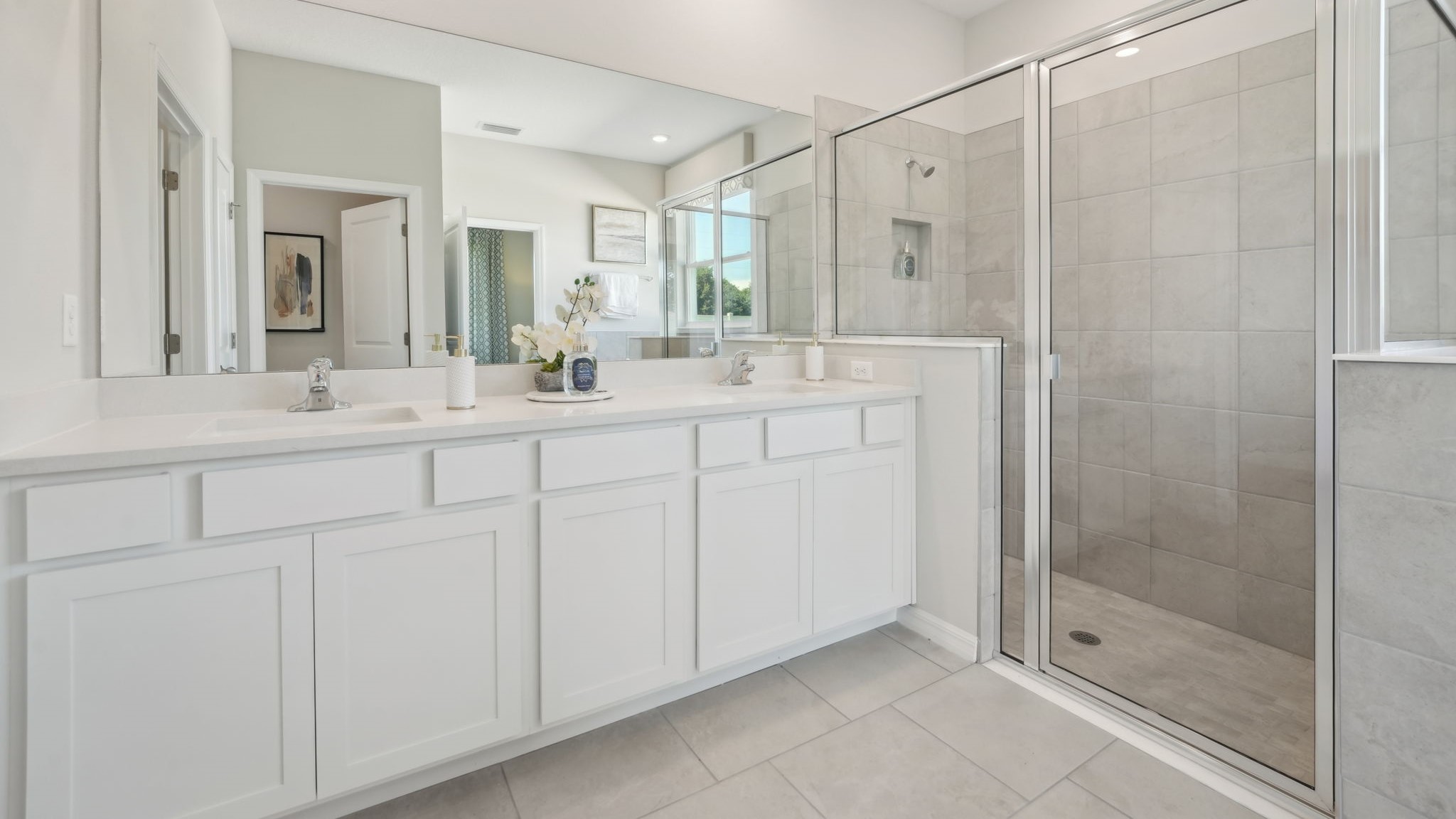 Modern bathroom with vanity sink, large wall mirror, and shower.