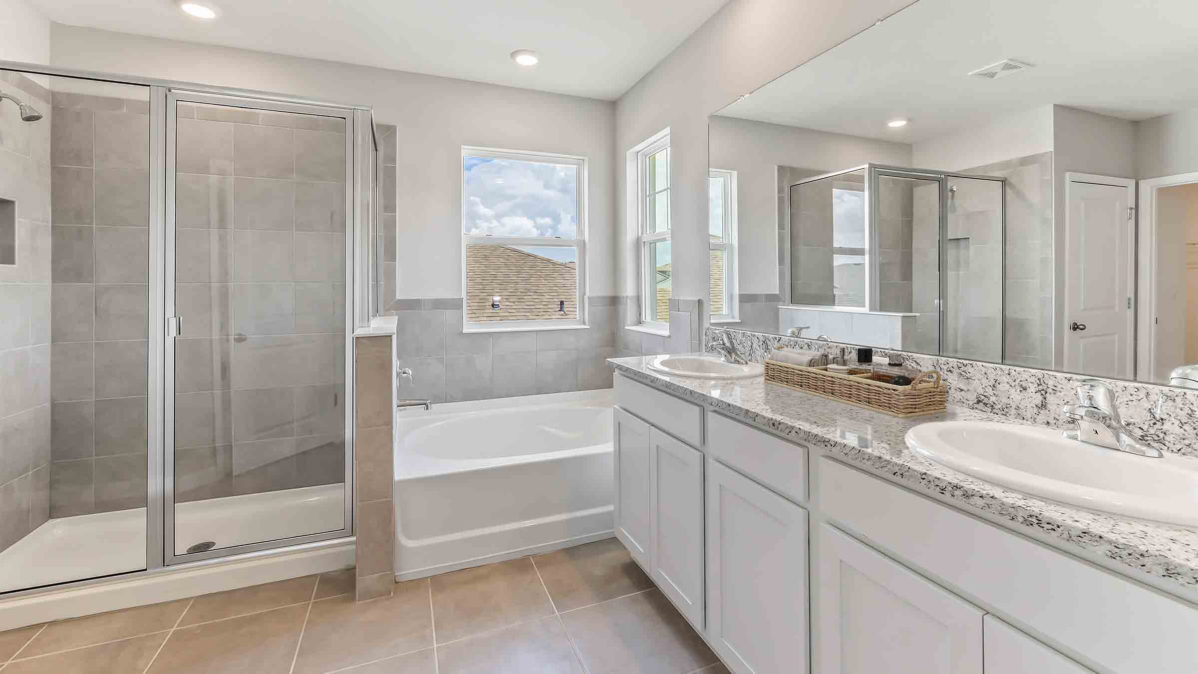 Modern bathroom with double vanity sinks, large wall mirror, cabinets and quartz countertops.