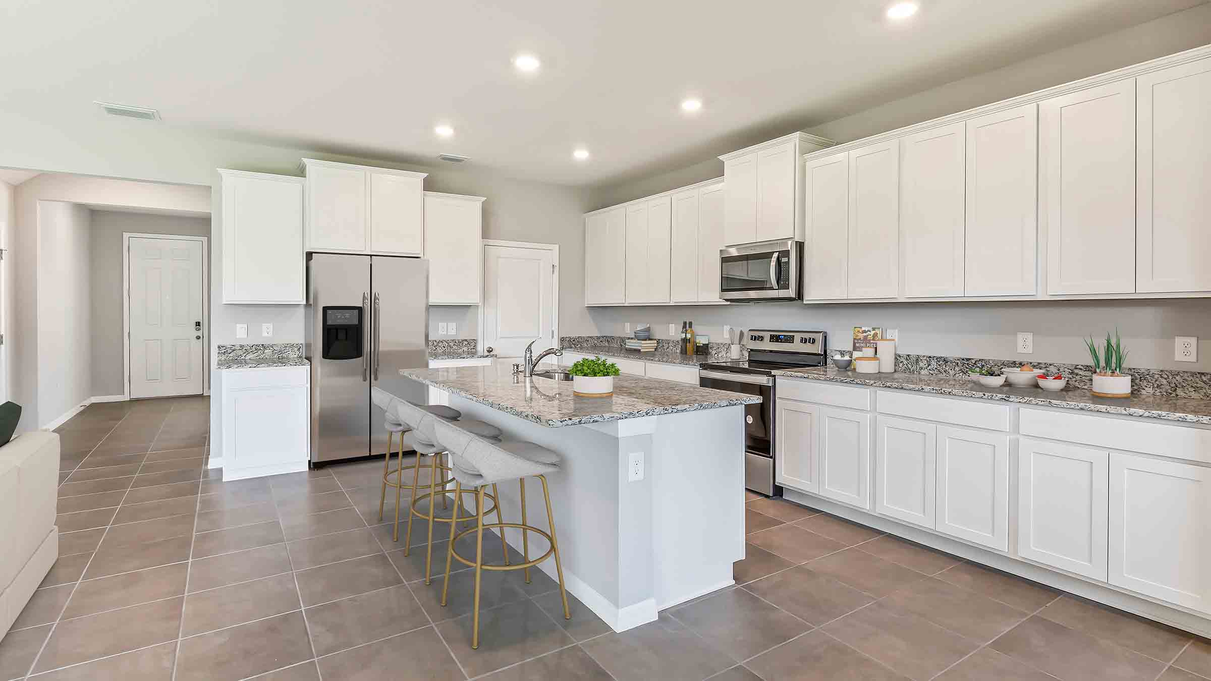 Kitchen with tall cabinetry, appliances, walk in pantry and LVP flooring.