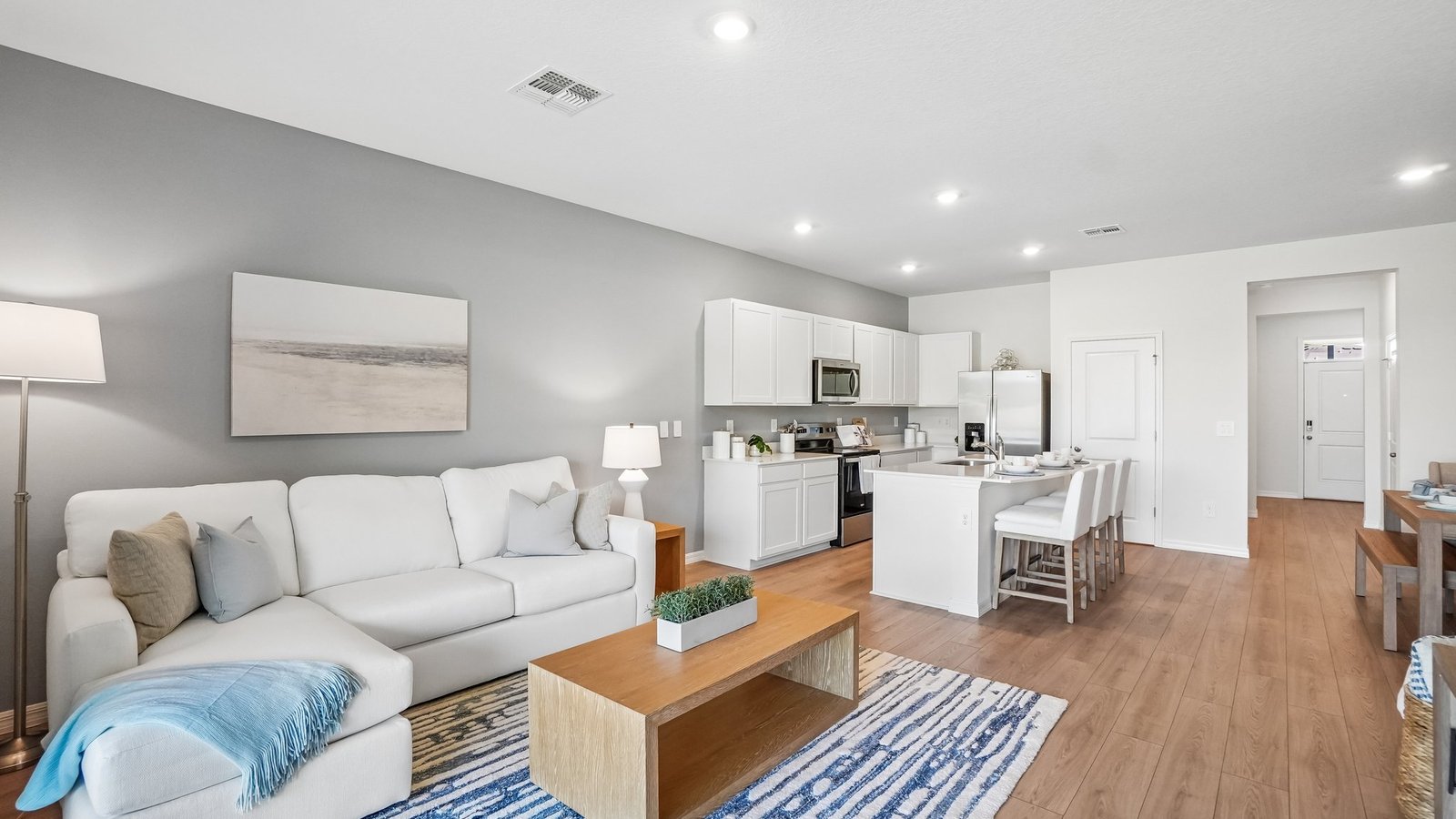 Open concept living area with couch seating and access to the backyard thru slider door.