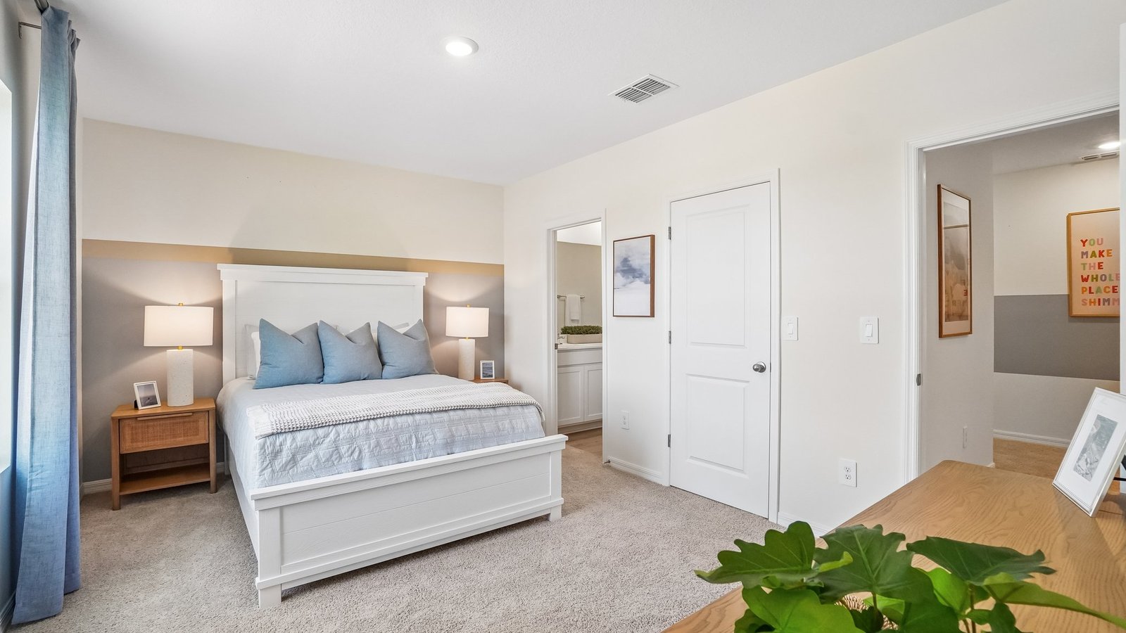 Spacious primary bedroom with king size bed, carpet flooring, natural lighting and a walk in closet.