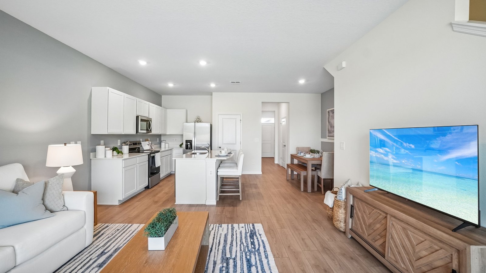 Open concept living area with couch seating and access to the backyard thru slider door.