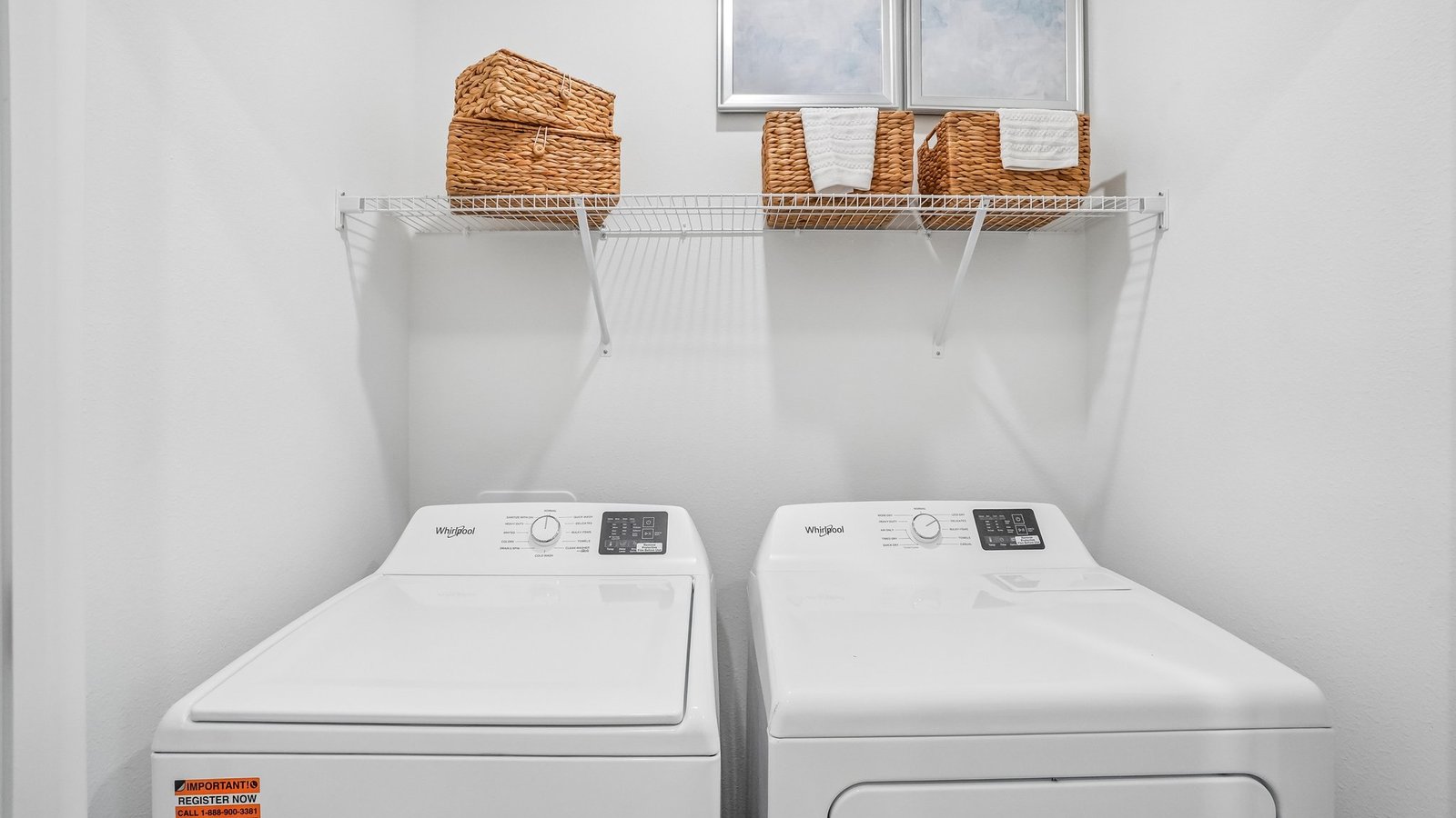 Laundry room with washer and dryer hookups and wall shelving.