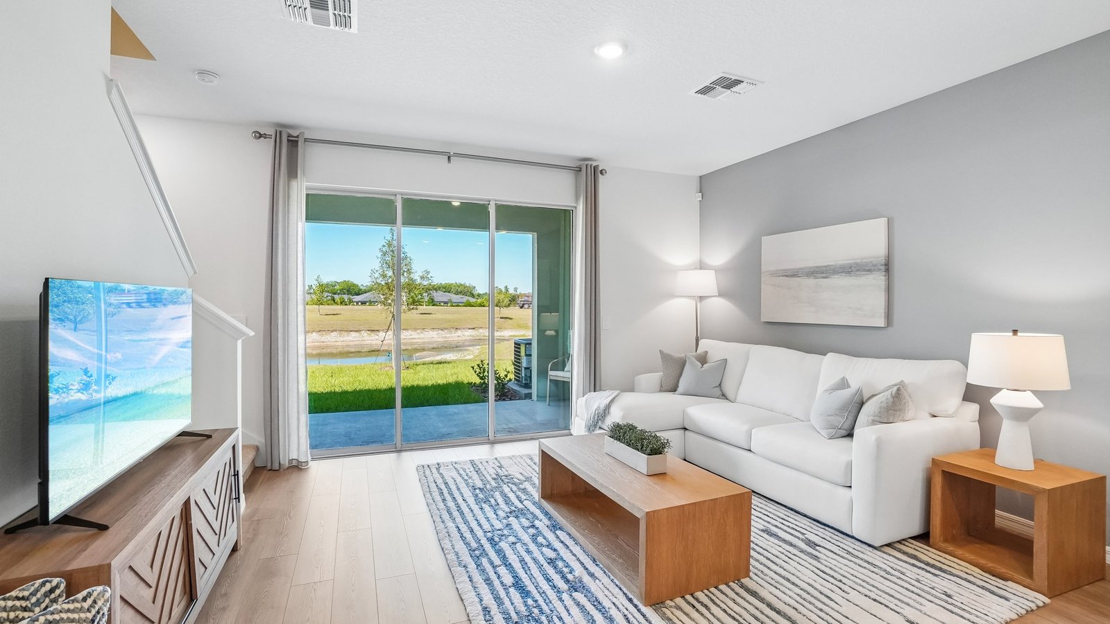 Open concept living area with couch seating and access to the backyard thru slider door.