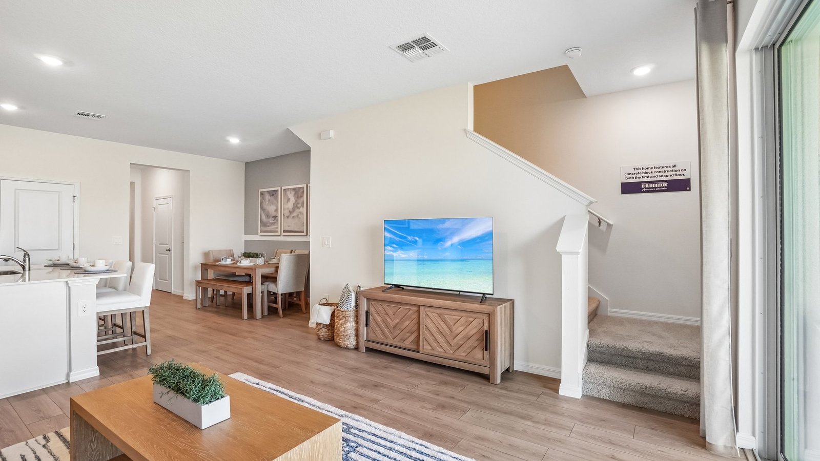 Open concept living area with couch seating and access to the backyard thru slider door.