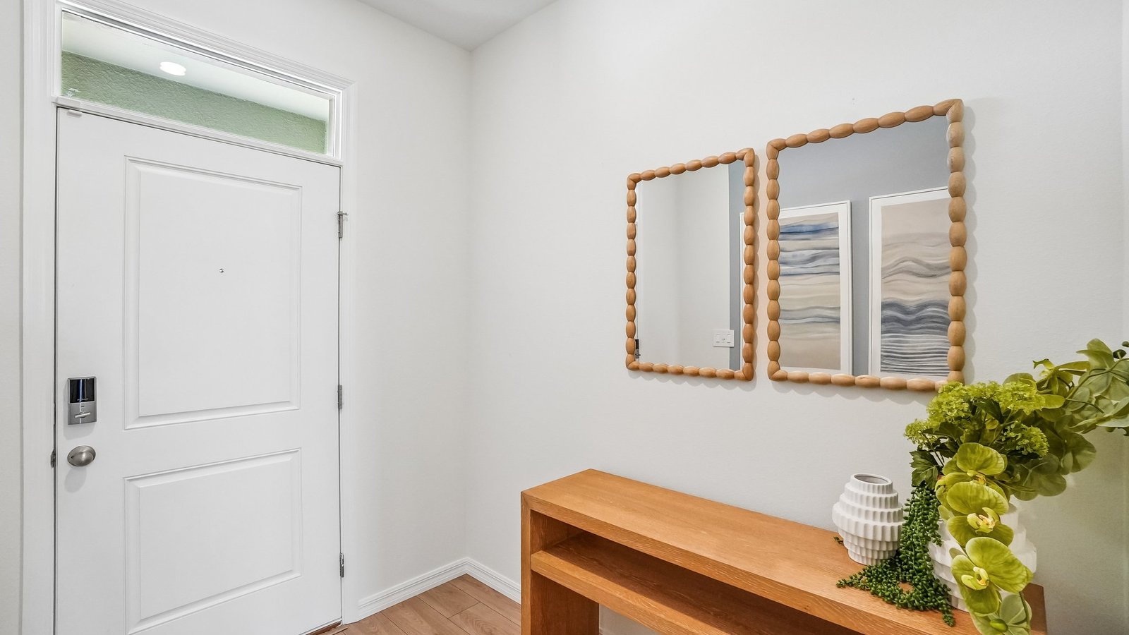 Home entry way thru the front door with LVP flooring and a view to the living space.