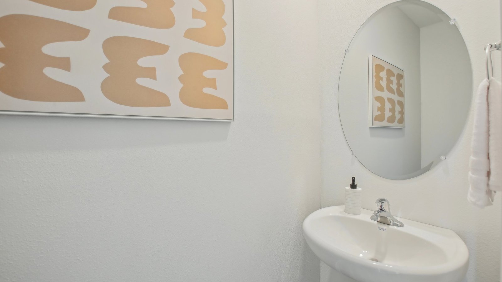 Modern bathroom with single bowl sink, quartz vanity, wall mirror, cabinets and toilet.