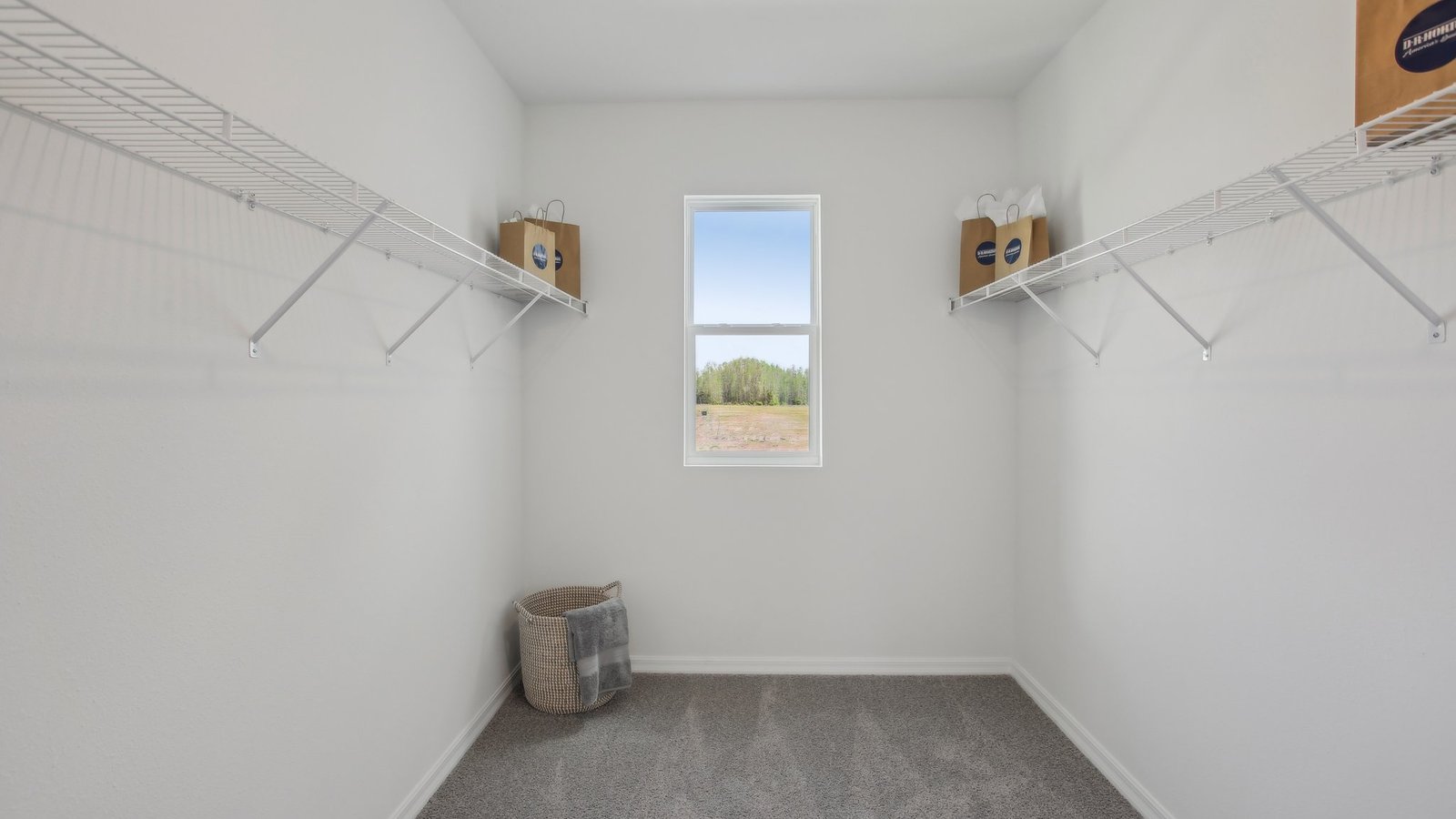 Spacious walk in closet with abundant shelving and storage.