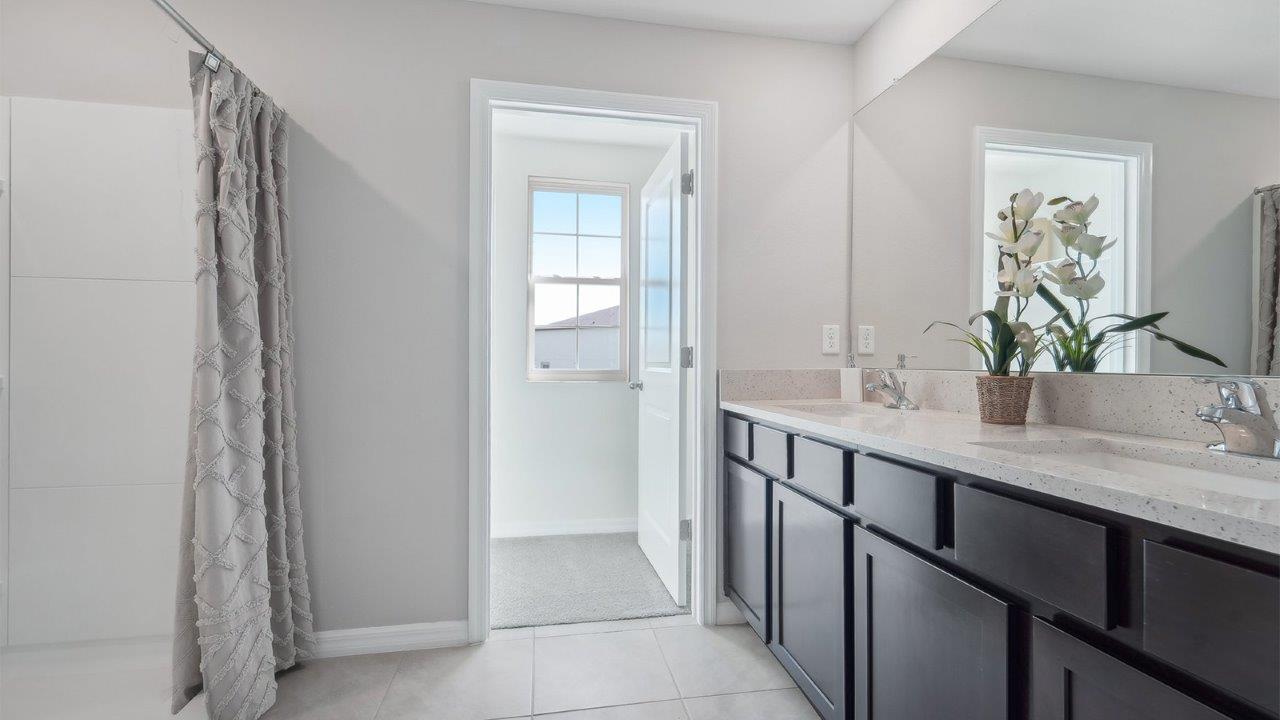 Modern bathroom with vanity sink, large wall mirror, and shower.