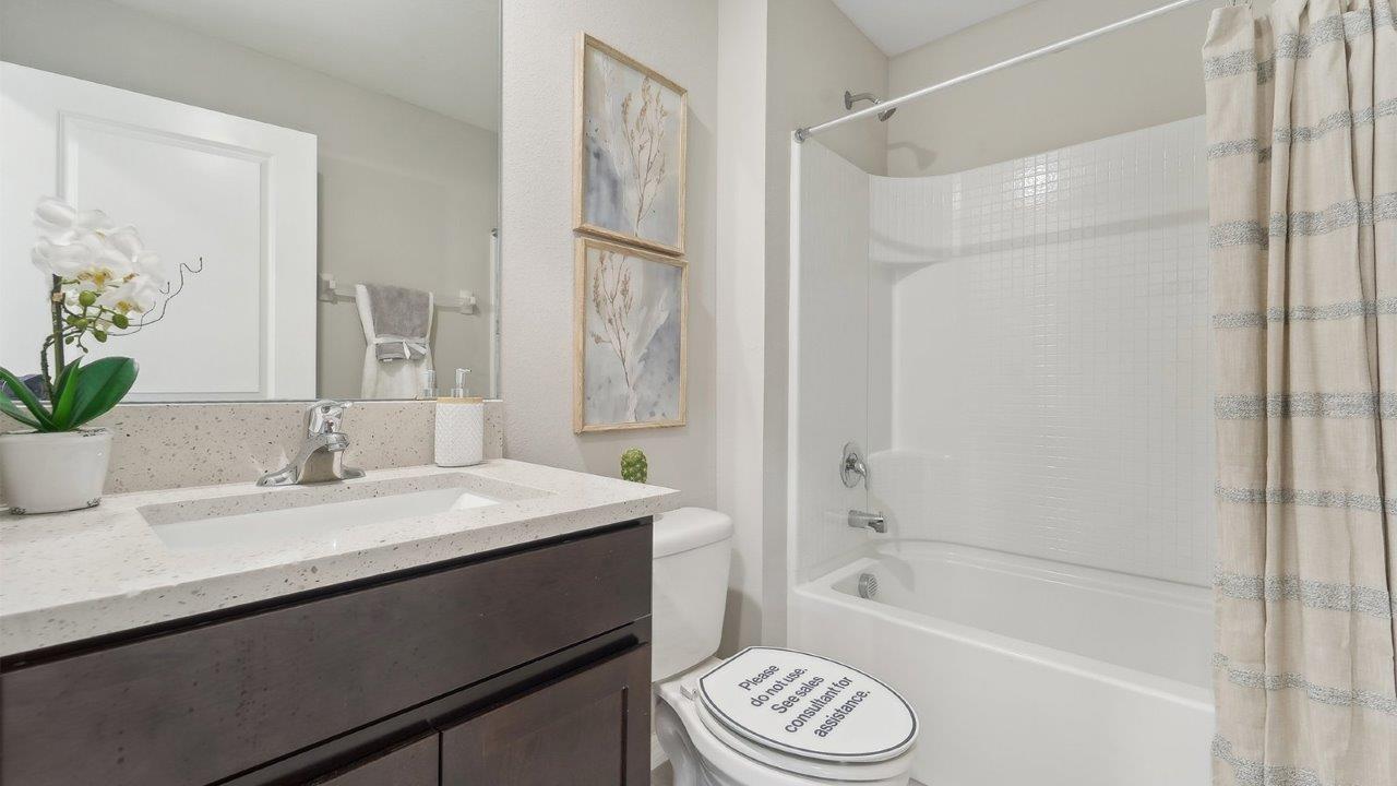 Modern bathroom with vanity sink, large wall mirror, and shower.