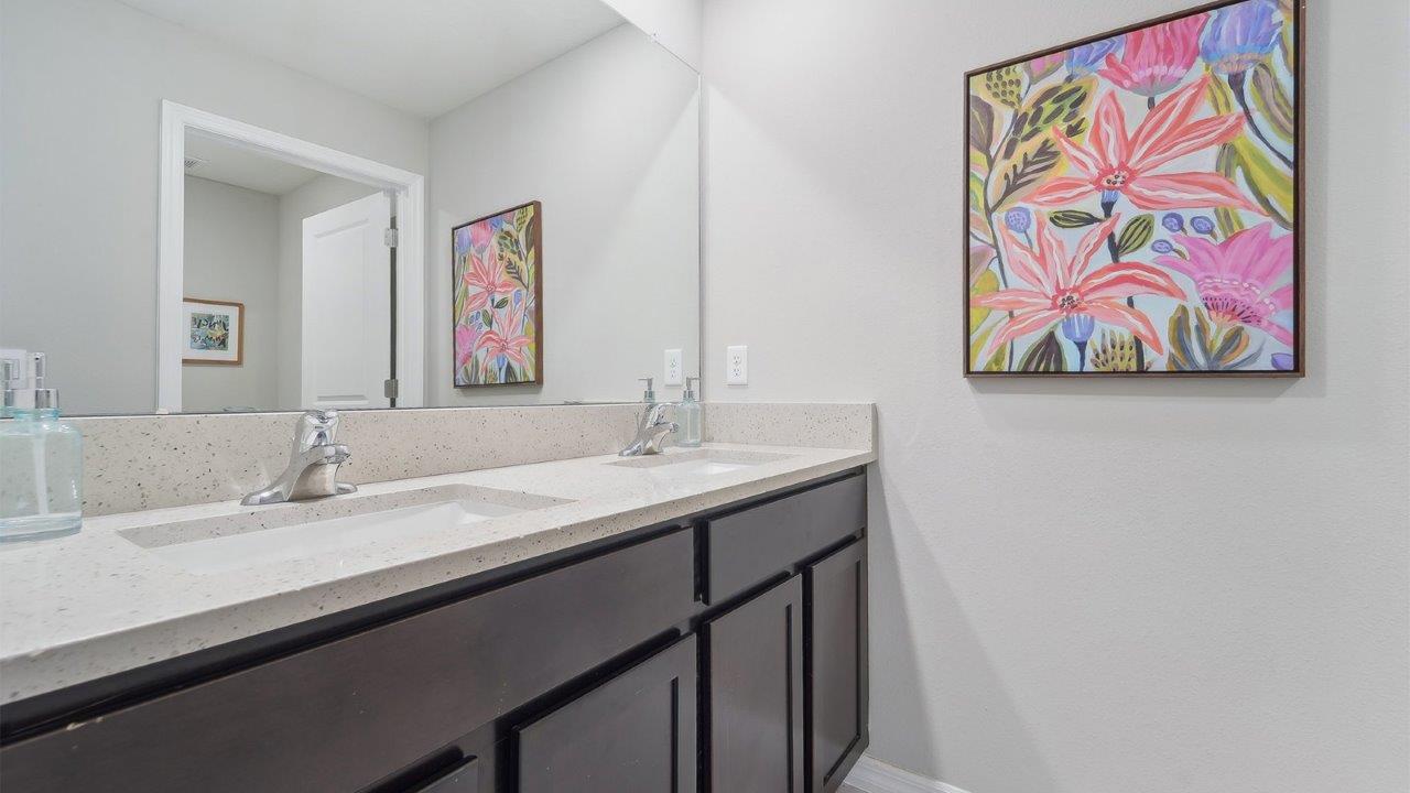 Modern bathroom with vanity sink, large wall mirror, and shower.