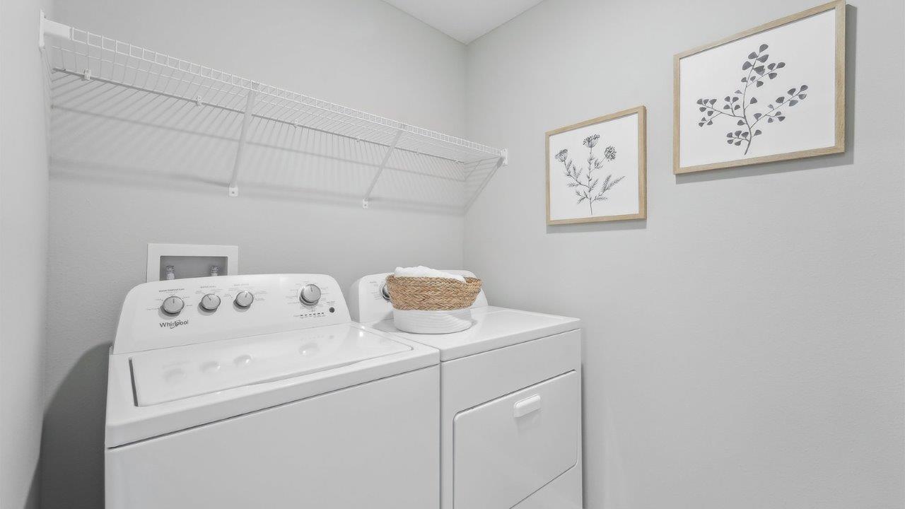 Laundry room with washer and dryer hookups and wall shelving.