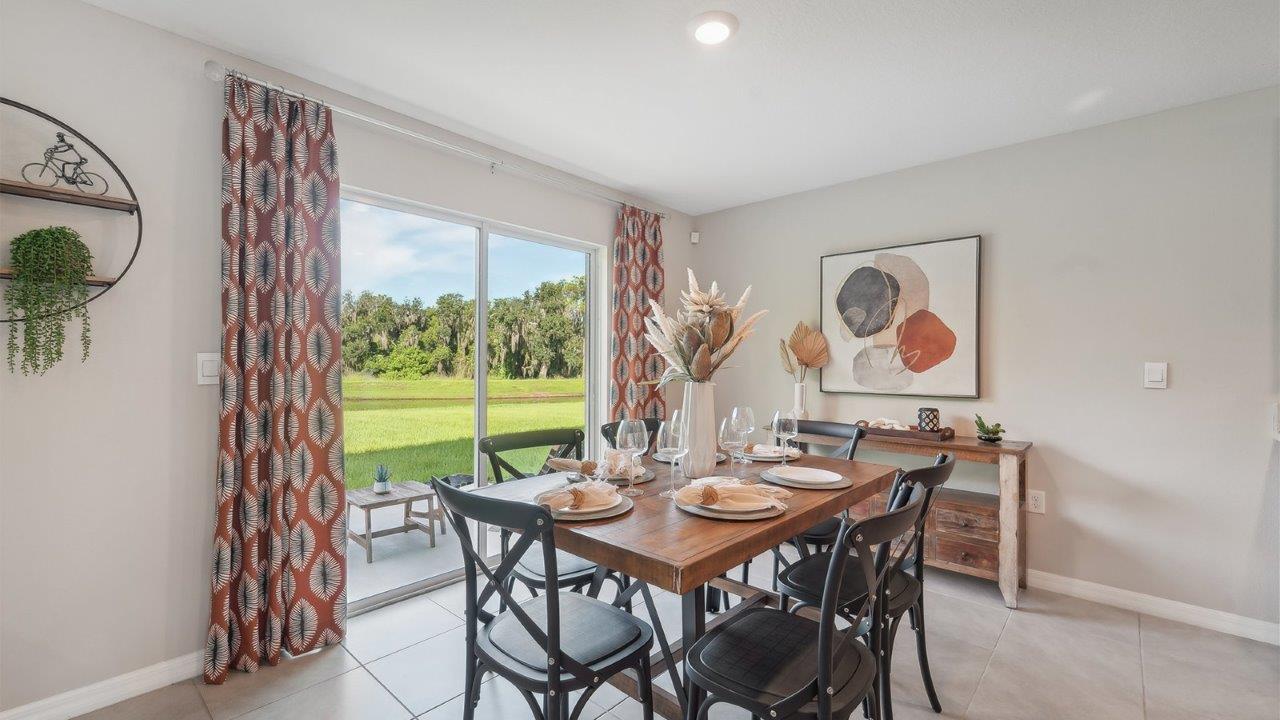 Dining room adjacent to the kitchen with table, chairs and tile flooring.