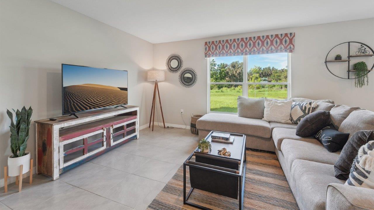 Open concept living area with couch seating and access to the backyard thru slider door.