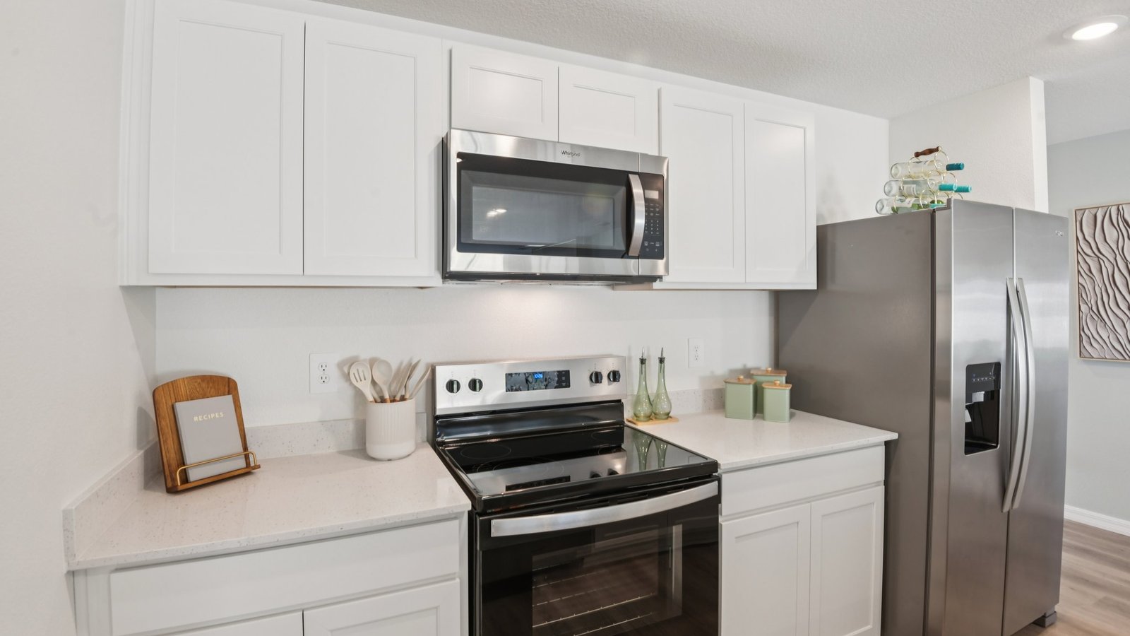 Kitchen with island seating, quartz counters, spacious pantry and stainless-steel appliances.