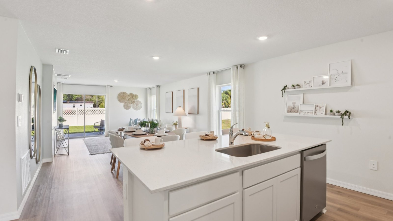 Kitchen with island seating, quartz counters, spacious pantry and stainless-steel appliances.