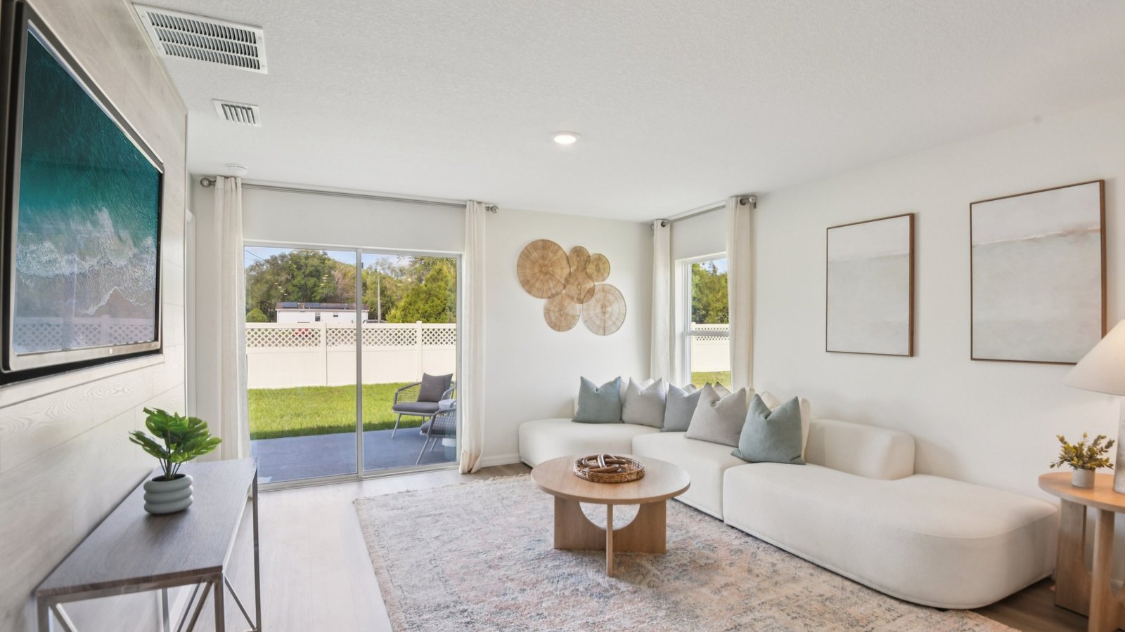 Open concept living area with couch seating and access to the backyard thru slider door.