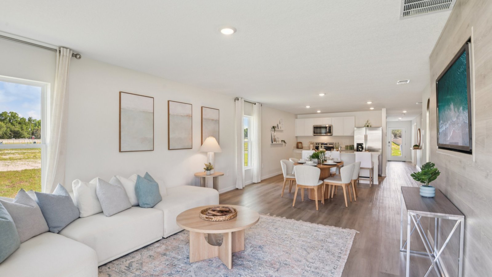 Open concept living area with couch seating and access to the backyard thru slider door.