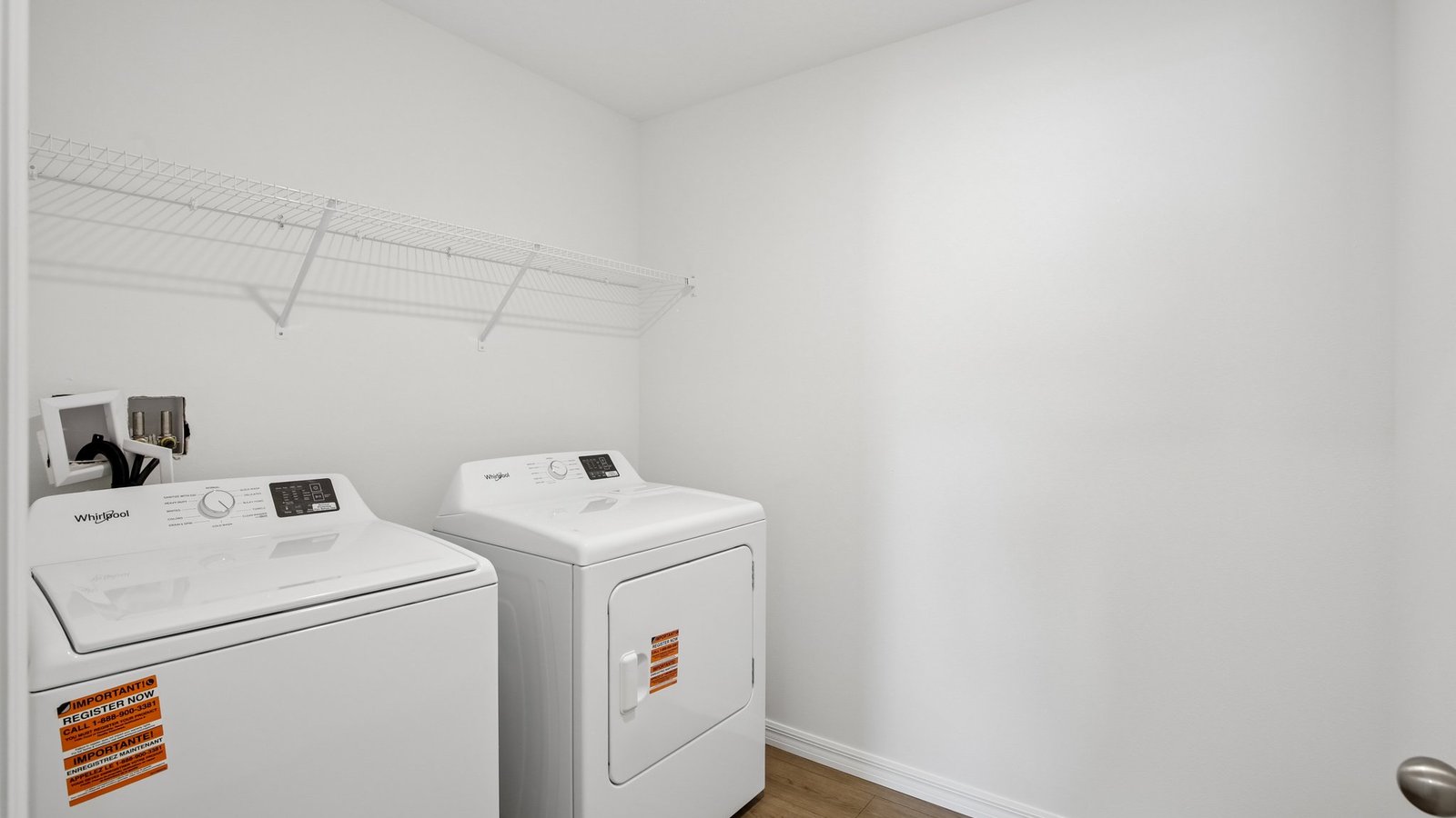 Laundry room with washer and dryer hookups and wall shelving.