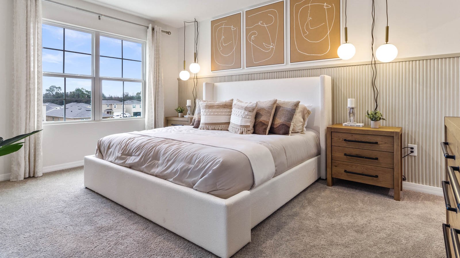 Spacious primary bedroom with king size bed, carpet flooring, natural lighting and a walk in closet.