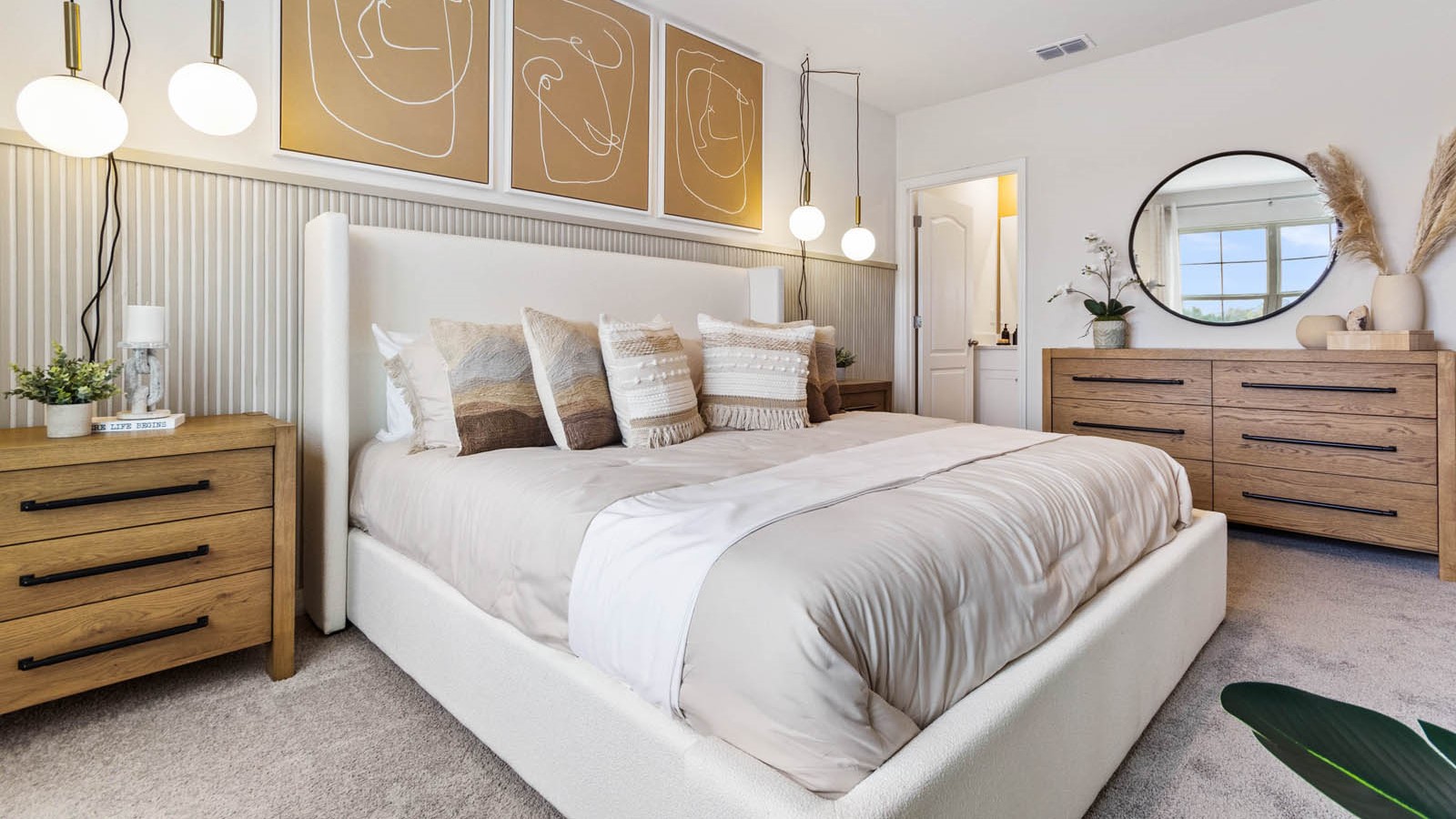 Spacious primary bedroom with king size bed, carpet flooring, natural lighting and a walk-in closet.