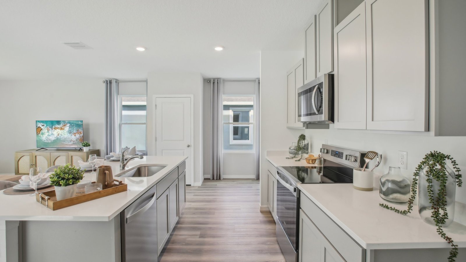 Kitchen with island seating, quartz counters, spacious pantry and stainless-steel appliances.