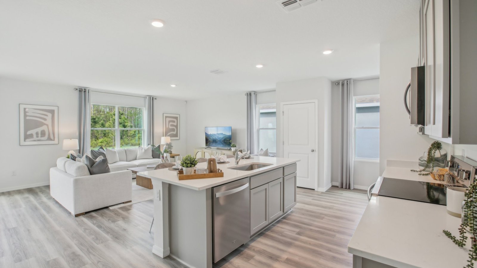 Kitchen with island seating, quartz counters, spacious pantry and stainless-steel appliances.