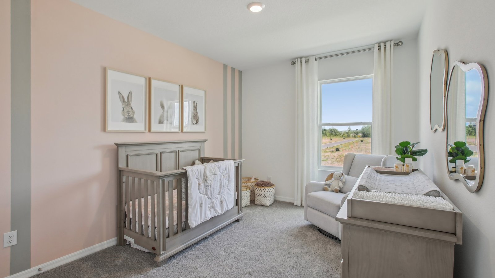 Child's nursery with crib, closet, soft seating and storage.