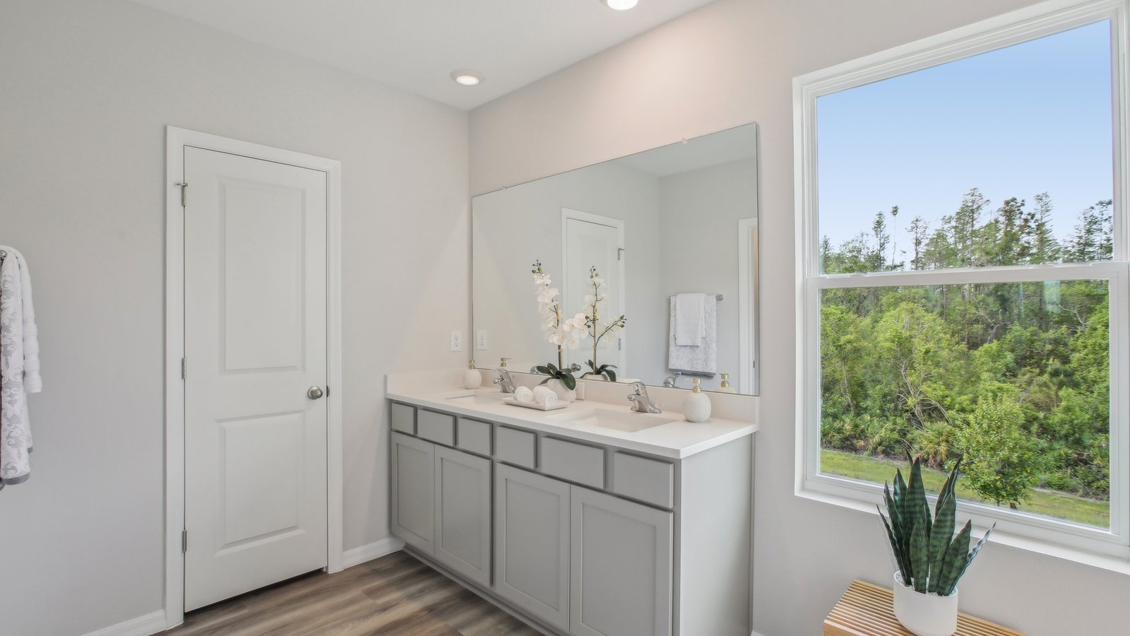 Modern bathroom with vanity sink, large wall mirror, and shower.