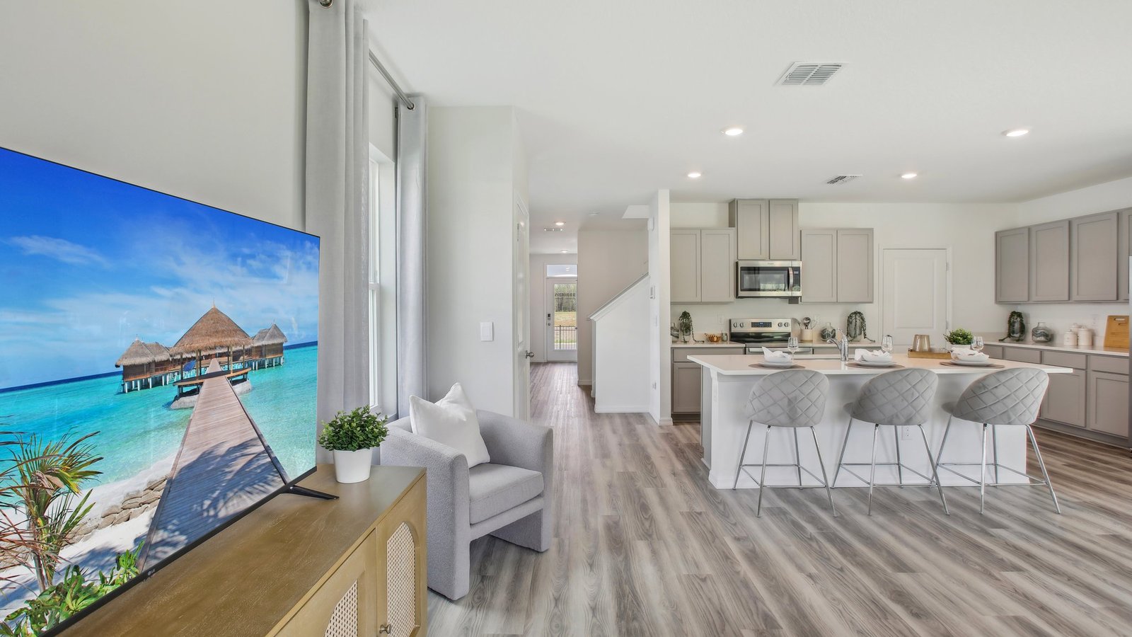 Open concept living area with couch seating and access to the backyard thru slider door.