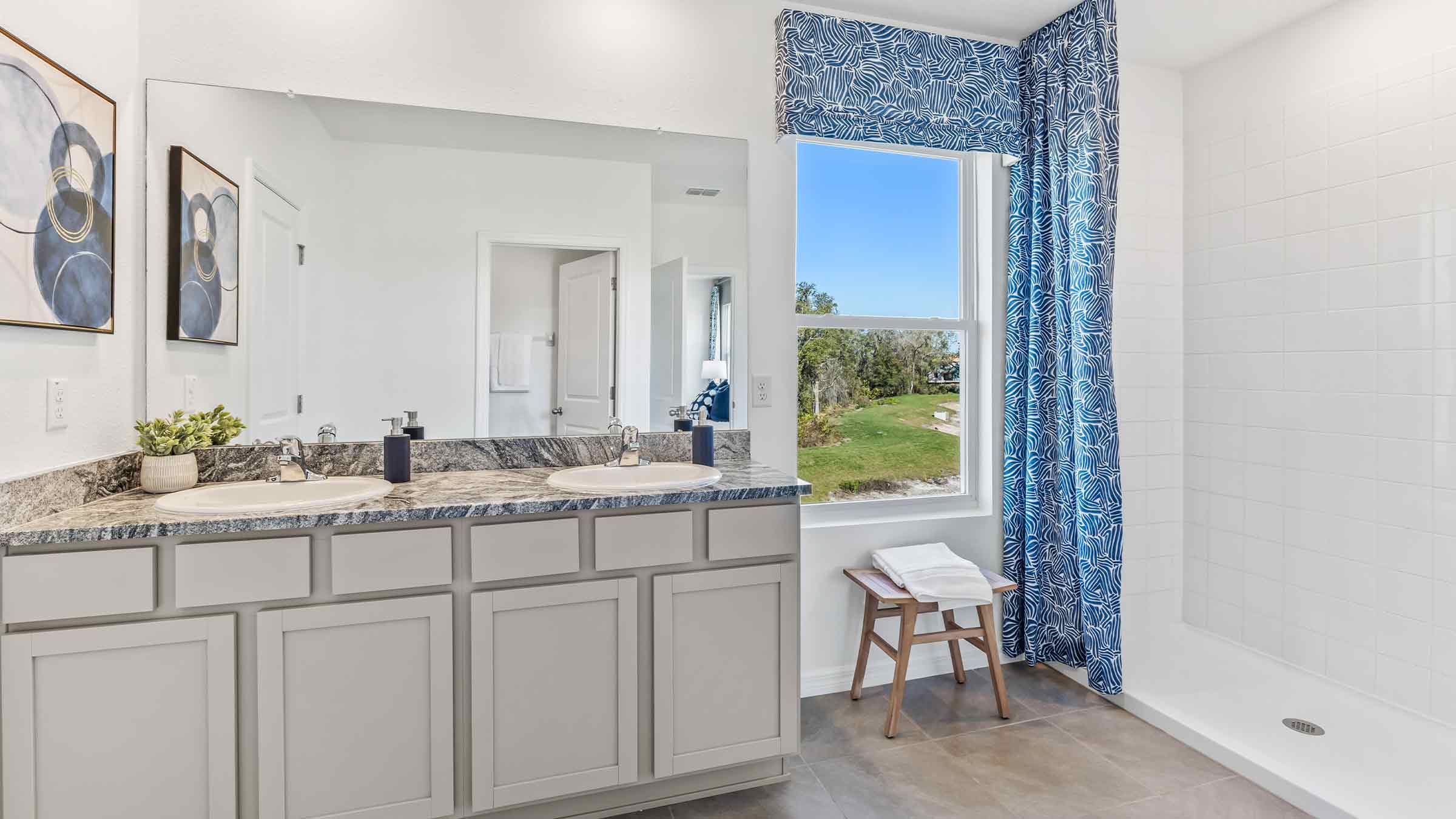 Modern bathroom with vanity sink, large wall mirror, and shower.